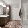 Apartments for Rent in Land O' Lakes, FL - Everwell at Bexley - Oversized Shower with White Subway Tile Backsplash, A Large Mirror, Quartz Countertops, Brown Cabinets, and Plank-Style Flooring